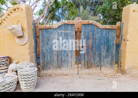 Faiyum, Egitto. Cancello di legno dipinto di blu in un muro nel villaggio di Faiyum. Foto Stock