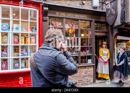 Il proprietario di affari femminile di York Ghost Merchant in piedi fuori del negozio di fantasmi in Shambles, York, Yorkshire, Inghilterra. Foto Stock