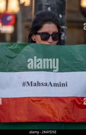 Barcellona, Spagna. 04th Ott 2022. Durante la manifestazione, un manifestante detiene una bandiera iraniana. Cento persone si sono riunite in Plaza de Catalunya in solidarietà con le donne che subiscono la repressione della dittatura islamica in Iran dopo l'assassinio di Masha Amini per mano della "polizia orale” per non aver indossato correttamente il velo obbligatorio. Credit: SOPA Images Limited/Alamy Live News Foto Stock