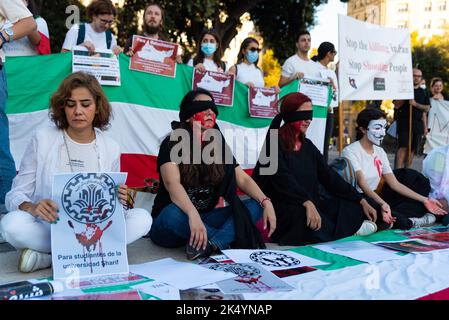 Barcellona, Spagna. 04th Ott 2022. Le donne siedono dipinte con la vernice rossa che tiene le bandiere a Barcellona, Spagna, il 04 ottobre 2022. Si sono tenute dimostrazioni in città di tutto il mondo per chiedere giustizia per l'uccisione di Mahsa Amini, una giovane donna che è stata detenuta a Teheran dalla polizia iraniana della morale per non aver indossato correttamente l'Hijab in pubblico. Credit: Sipa USA/Alamy Live News Foto Stock