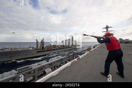 OCEANO ATLANTICO (23 marzo 2022) Seaman Darius Webb, di Chicago, assegnato al reparto armi a bordo della portaerei USS Gerald R. Ford (CVN 78), spara una linea messaggera per il rifornimento della flotta USNS Kanawha (T-AO 196) durante un rifornimento in mare nell'Oceano Atlantico, 23 marzo 2022. Gerald R. Ford sta conducendo la certificazione del ponte di volo e le qualifiche del vettore aereo come parte della fase di base su misura di shipÕs prima dell'implementazione operativa. (STATI UNITI Foto Navy di Mass Communication Specialist 2nd Classe Zack Guth) Foto Stock