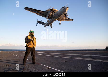 KARLSKRONA, Svezia (20 aprile 2022) Aviation Boatswain's Mate (Equipment) 1st Class Aaron Wilson, di Atlanta, assegnato al reparto aereo a bordo della portaerei USS Gerald R. Ford (CVN 78), Gli stand osservano come l'ufficiale di arresto degli attrezzi come un Hawkeye E2-D attaccato al 'Aces dell'orso' dello squadrone di controllo e di comando di Airborne (VAW) 124 vola sopra il ponte di volo, 19 aprile 2022. Gerald R. Ford è in corso nell’Oceano Atlantico, dirigendo le qualifiche dei vettori e conducendo l’integrazione dei gruppi di sciopero come parte della fase di base su misura della nave prima dello spiegamento operativo. Foto Stock