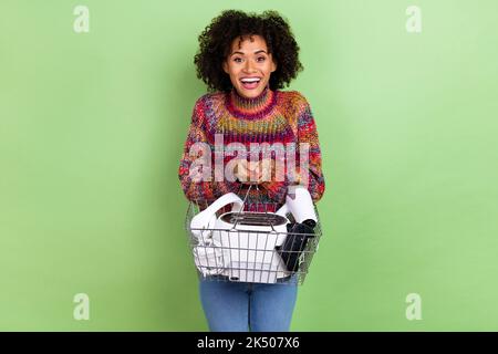 Foto di giovane impressionato wavy hairstyle donna hold TECH indossare dolcevita rosso isolato su sfondo di colore verde Foto Stock