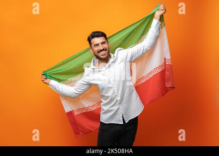 Ritratto di un giovane uomo casual con bandiera dell'Iran su sfondo arancione Foto Stock