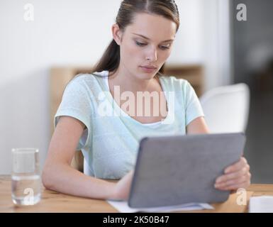 Utilizzare la tecnologia per svolgere il lavoro. Una giovane e attraente donna d'affari che utilizza un dispositivo wireless. Foto Stock