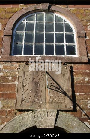 Primo piano della finestra e della meridiana sopra la porta d'ingresso alla Chiesa Vecchia di San Giovanni a Pilling, Lancashire, con la chiave di volta datata 1717 sopra la porta. Foto Stock