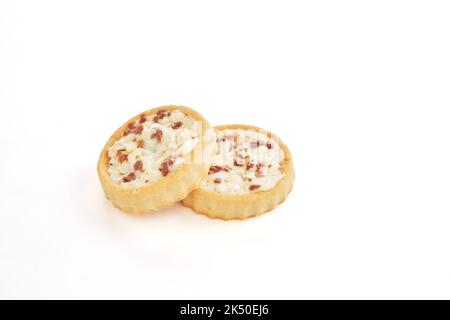 Biscotti al cioccolato e farcitura di crema, grani germogliati e pezzi di cioccolato su fondo bianco Foto Stock