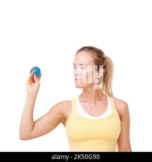 Schiacciando via le sue preoccupazioni. Vista ritagliata di una donna che stringe una palla stress su uno sfondo bianco. Foto Stock