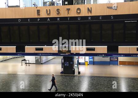 Una persona che passa davanti al bordo vuoto delle partenze alla stazione di Euston a Londra, mentre i membri del sindacato dei conducenti di Aslef e della Transport Salaried Staffs Association (TSSA) vanno in sciopero. Data immagine: Mercoledì 5 ottobre 2022. Foto Stock