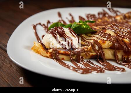Pancake con un cucchiaio di gelato e cioccolato. Primo piano, messa a fuoco selettiva Foto Stock