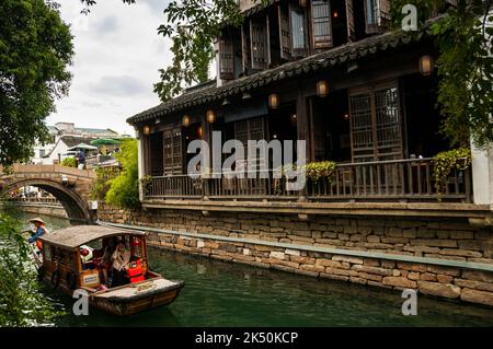 Una barca turistica che passa davanti ad una casa da tè sul Fiume Pingjiang lungo Pingjiang Lu una strada piena di edifici di vecchio stile a Suzhou, nella Provincia di Jiangsu, Cina Foto Stock