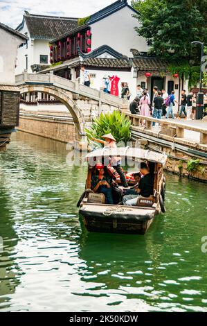 Una barca turistica sul fiume Pingjiang lungo Pingjiang Lu una strada piena di edifici di vecchio stile a Suzhou, Provincia di Jiangsu, Cina. Foto Stock