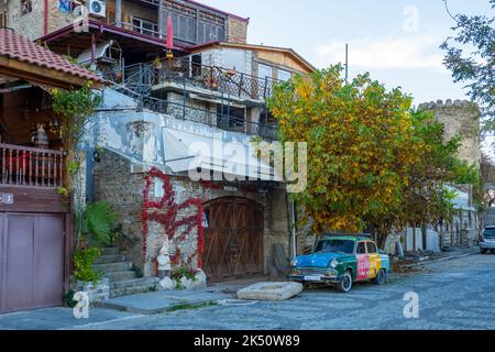 Auto retrò parcheggiata vicino a vecchie case residenziali nel centro storico Foto Stock