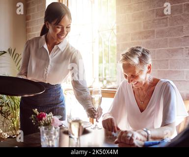 Ristorante, cameriera e degustazione di vini per lusso, festeggiamenti o cene raffinate in un vigneto o nel settore alberghiero. Servizio sommelier Foto Stock