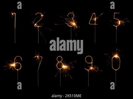 Golden Sparklers in cifre forma set, che brucia luminoso con scintille, isolato su sfondo nero Foto Stock
