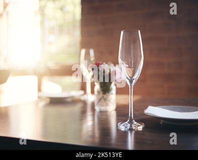 Bicchiere vuoto sul tavolo per vino, champagne o alcol a cena nel romantico ristorante, casa o cena. Lusso, pranzo o cena con bicchiere di vino di cristallo Foto Stock