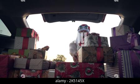 babbo natale consegna di regali. regali da babbo natale. servizio di consegna. consegna di pacchi. confezioni regalo in auto. pacchi confezionati con cura. vista dall'interno dell'auto. concetto di donazione, beneficenza o consegna. Foto di alta qualità Foto Stock