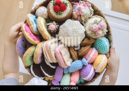 Cibo giocattolo lavorato a maglia da filato. Dolci, dolci, biscotti e torte. Foto Stock