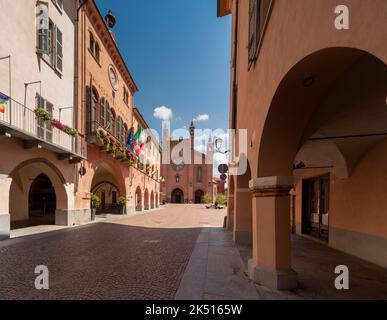 Alba, Langhe, Piemonte, Italia - 16 agosto 2022: Via Cavour con portici medievali e il Municipio con balconi fioriti, sullo sfondo Cathedr Foto Stock