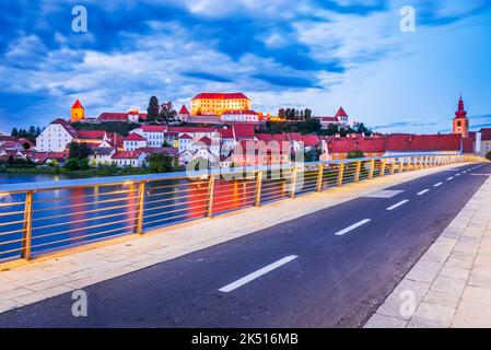 Ptuj, Slovenia. Scena notturna con la bellissima città antica Poetovium, la più antica città slovena, riva del fiume Drava con il Castello sulla collina. Foto Stock