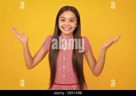 Faccia eccitata. Ritratto di ragazza gioiosa con le mani sollevate. Adolescente caucasico urlando isolato su giallo. Bambino felice esclamando con gioia e. Foto Stock