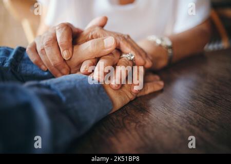 Fiducia, amore e coppia anziane che tengono le mani per sostentarsi a vicenda nel matrimonio, nella vita e nella pensione con empatia. Gratitudine, comprensione e anziani Foto Stock