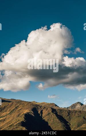 Nuvola bianca spessa che galleggia nel cielo blu sulla catena montuosa dei Pirenei il giorno d'estate a Lleida, Catalogna, Spagna Foto Stock