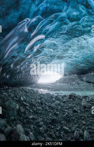 Interno di una grotta di ghiaccio mozzafiato con pavimento bagnato all'interno del ghiacciaio Vatnajokull il giorno d'inverno in Islanda Foto Stock