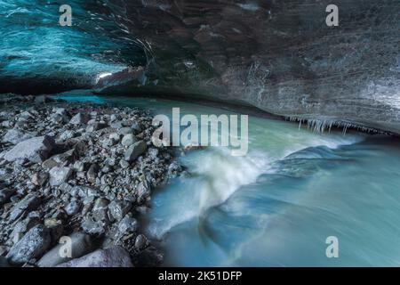 Interno di una grotta di ghiaccio mozzafiato con pavimento bagnato all'interno del ghiacciaio Vatnajokull il giorno d'inverno in Islanda Foto Stock