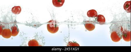 Molti pomodori spruzzano in acqua. Vista laterale panoramica su sfondo bianco. Foto Stock