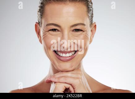 Cura della pelle, anti invecchiamento e bella donna matura con un sorriso sul viso su sfondo bianco. Bellezza, botox e collagene, una donna di mezza età dagli Stati Uniti Foto Stock