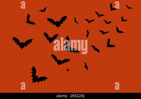 Terrificanti pipistrelli neri su sfondo arancione scuro di Halloween. Silhouettes di pipistrelli volanti sono simboli tradizionali di Halloween. Decorazione di carta per le feste p Foto Stock