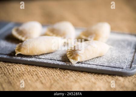 Gnocchi crudi con patate. Gnocchi che cucinano su un tagliere di cucina. Foto Stock