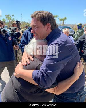 Matlacha Isles, Florida, (ott 4, 2022) - l'uragano Ian Survivor abbraccia il governatore della Florida Ron DeSantis. Foto Stock