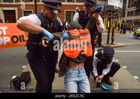 Londra, Regno Unito. 5th ottobre 2022. Arresto della polizia basta fermare i manifestanti di petrolio che bloccano Horseferry Road. Alcuni attivisti hanno incollato le mani alla strada, e la protesta è stata parte di una serie di manifestazioni che si svolgono quotidianamente a Westminster, con il gruppo di azione sul clima che chiede di porre fine ai combustibili fossili e di passare alle energie rinnovabili. Credit: Vuk Valcic/Alamy Live News Foto Stock