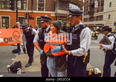 Londra, Regno Unito. 5th ottobre 2022. Arresto della polizia basta fermare i manifestanti di petrolio che bloccano Horseferry Road. Alcuni attivisti hanno incollato le mani alla strada, e la protesta è stata parte di una serie di manifestazioni che si svolgono quotidianamente a Westminster, con il gruppo di azione sul clima che chiede di porre fine ai combustibili fossili e di passare alle energie rinnovabili. Credit: Vuk Valcic/Alamy Live News Foto Stock