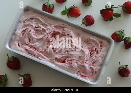 Gelato alla fragola fatto in casa estratto dal freezer in una latta di pane. Gelato a tre ingredienti fatto di fragole fresche, panna o panna montata Foto Stock