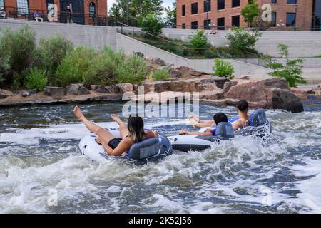 Gli amici si divertono a galleggiare lungo il fiume South Platte a Denver su barche gonfiabili in Colorado USA Foto Stock