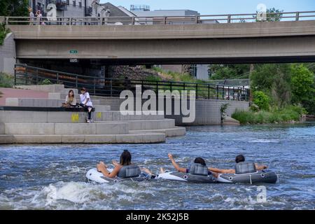 Tre amici galleggiano lungo il fiume South Platte in una calda giornata sui gonfiabili a Denver, Colorado Foto Stock