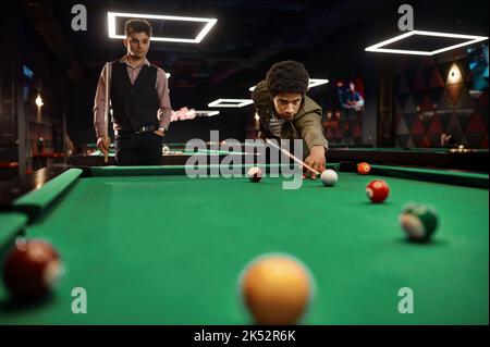 Gli amici stanno giocando a biliardo nel club Foto Stock