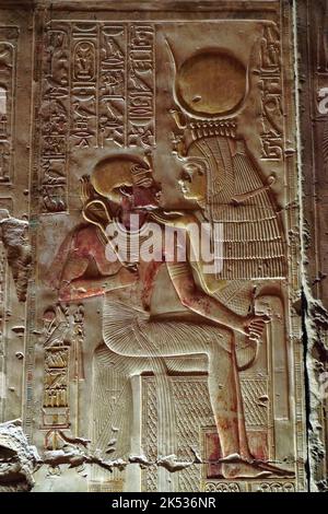 Egitto, Medio Egitto, Valle del Nilo, Abydos, tempio di Seti 1, bassorilievo che mostra la dea Iside indossando la corona di Hathor con il giovane faraone set Foto Stock