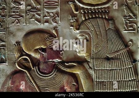 Egitto, Medio Egitto, Valle del Nilo, Abydos, tempio di Seti 1, bassorilievo che mostra la dea Iside indossando la corona di Hathor con il giovane faraone set Foto Stock