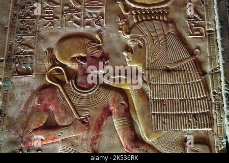 Egitto, Medio Egitto, Valle del Nilo, Abydos, tempio di Seti 1, bassorilievo che mostra la dea Iside indossando la corona di Hathor con il giovane faraone set Foto Stock