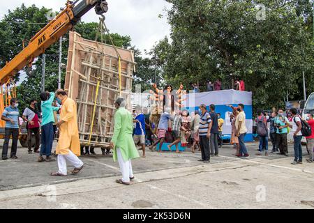 Il lavoro di immersione di Durga idol è in corso a Ganga Ghat di Kolkata. Il grande idolo viene portato al fiume da una gru. Foto Stock