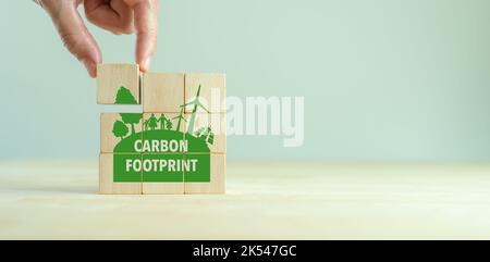 Impronta di carbonio, concetto di emissioni zero. Simboli di impronta ecologica al carbonio su cubi di legno con icone ecocompatibili. Strategia di sviluppo sostenibile Foto Stock