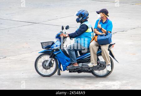 SAMUT PRAKAN, THAILANDIA, ottobre 03 2022, Un tassista su una moto ride con una donna. Foto Stock