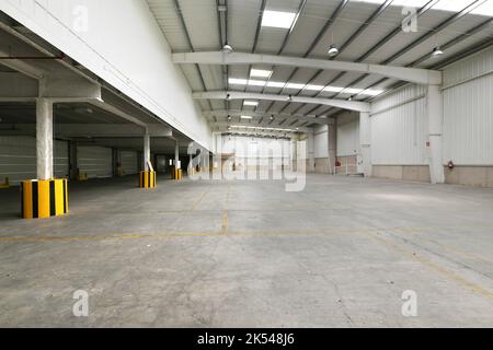 Edificio industriale vuoto con pavimenti in cemento, travi a forma di costola in calcestruzzo prefabbricato Foto Stock