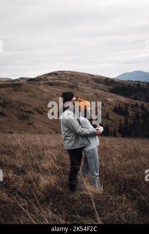 Giovane coppia godendo paesaggio di montagne autunnali. Sfondo collina nuvoloso Foto Stock