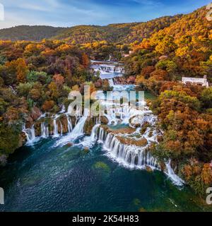 Krka, Croazia - veduta aerea panoramica delle famose cascate di Krka nel Parco Nazionale di Krka in una luminosa mattinata autunnale con coloratissime foglie autunnali e. Foto Stock