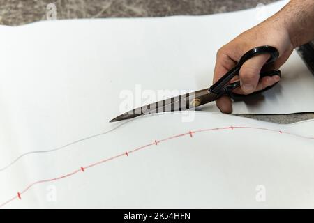 Tappezzeria taglio pezzi di pelle con forbici per riparare un sedile, copia spazio Foto Stock